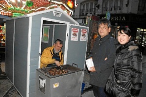 Una pareja de turistas compran castañas en el puesto de José.